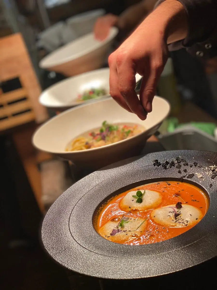 Tomatencremesuppe mit Blütenschaum, wird mit Salz verfeinert