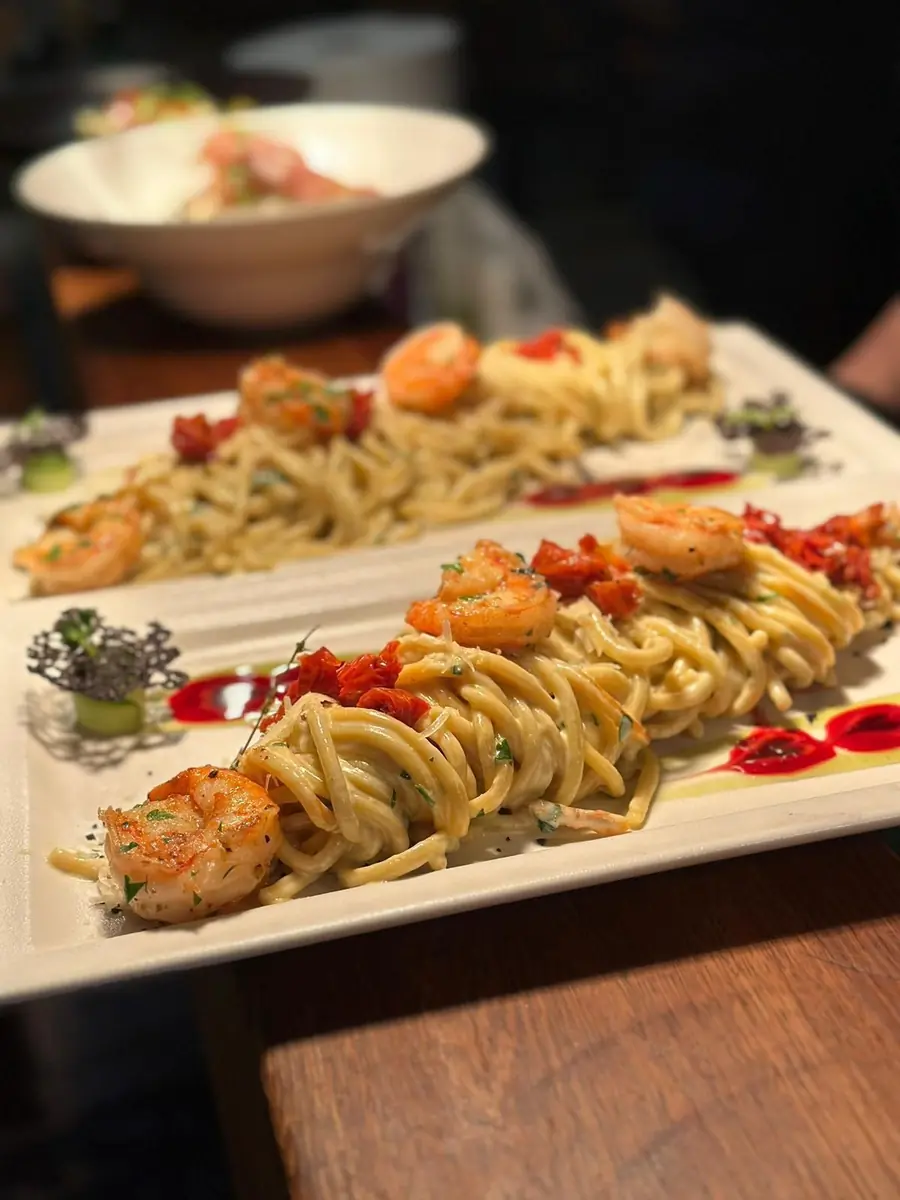 Spaghetti mit Garnelen und getrockneten Tomaten auf weißen Tellern