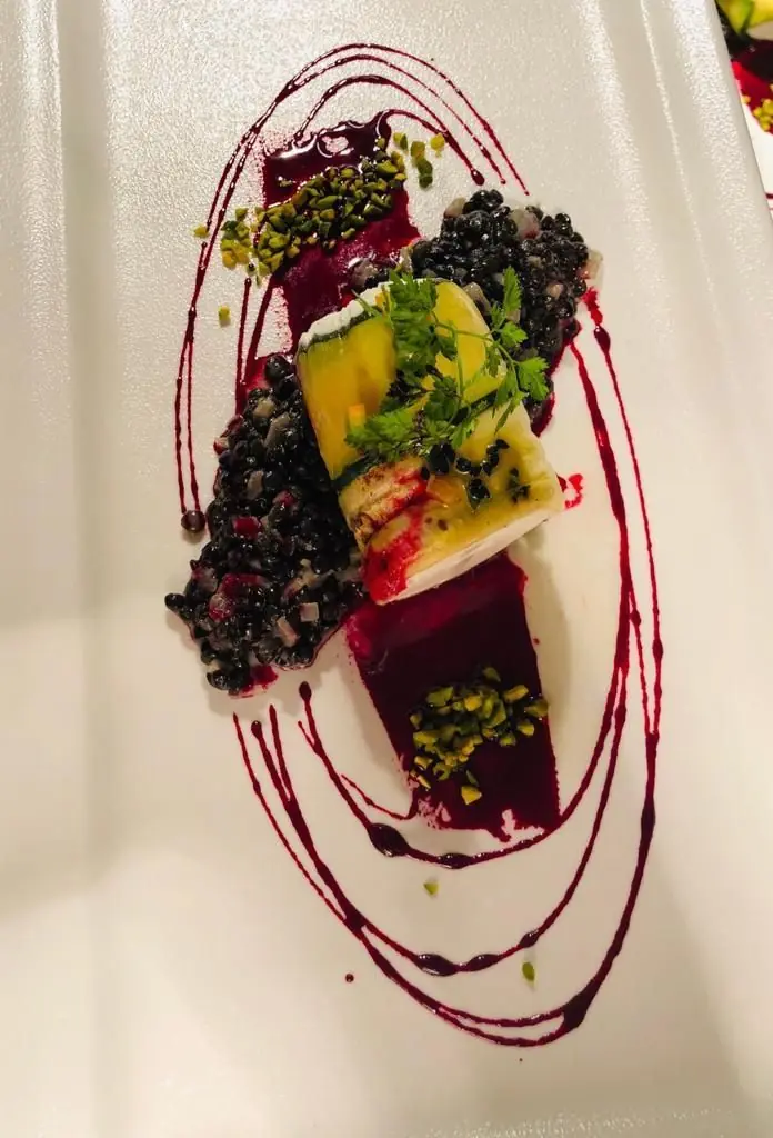 Zucchini-Röllchen auf Beluga-Linsen mit Rote-Bete-Sauce und Pistazien